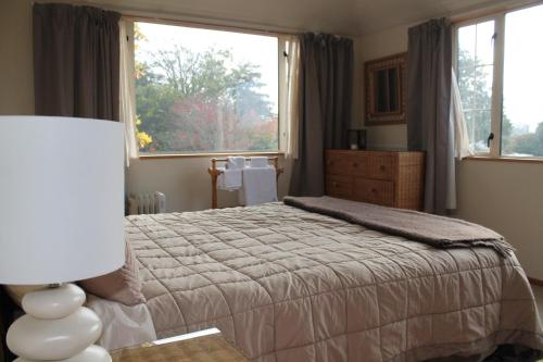 a bedroom with a bed and a large window at Aroha Riccarton Bed and Breakfast in Christchurch