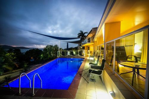 une piscine sur le côté d'un immeuble dans l'établissement Sunlit Waters Studio Apartments, à Airlie Beach