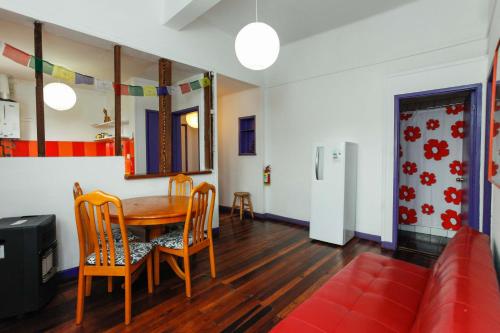 a dining room with a table and chairs and a couch at Casa Violeta Limón in Valparaíso