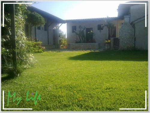 a yard with green grass and a house at MyLife B&B Country House in Castellaneta Marina 
