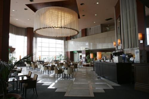 a restaurant with a large chandelier and tables and chairs at Utazu Grand Hotel in Utazu