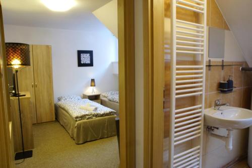 a bathroom with a sink and a bed in a room at Hostinské pokoje U Kulináře in Domažlice