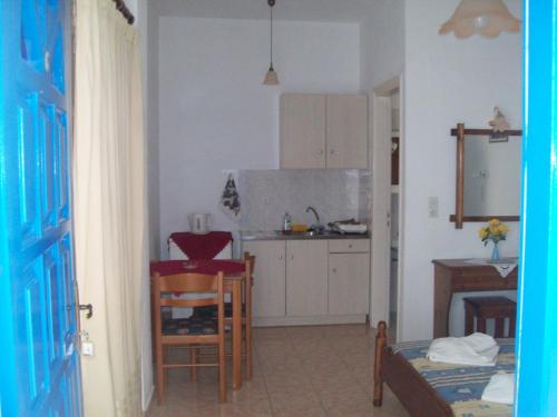 a kitchen with a small table and a kitchen with a counter at Spiridoula Villa - Santorini Seaside Retreats in Perissa