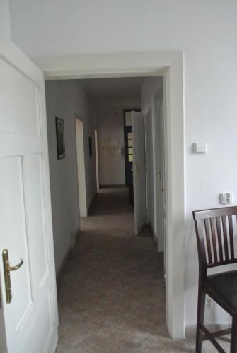 an empty hallway with a chair and a room at Zajazd pod Zamkiem in Kętrzyn