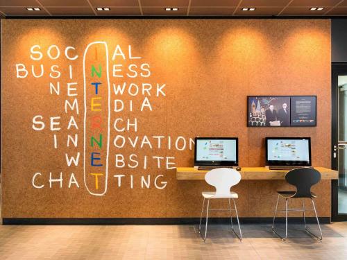 a wall with writing on it in a office at Ibis München Airport Süd in Hallbergmoos