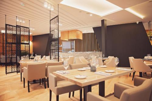 a restaurant with tables and chairs in a room at Hotel New Skanpol in Kołobrzeg