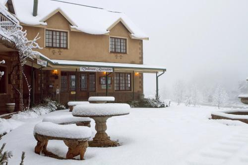 a snow covered building with a fountain in front of it at Auldstone House in Dullstroom