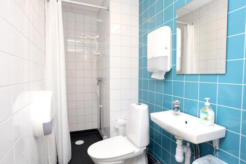 een blauwe en witte badkamer met een toilet en een wastafel bij Citysleep in Luleå