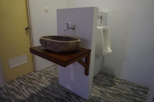 a bathroom with a stone sink and a urinal at M BOX Gili Trawangan in Gili Trawangan