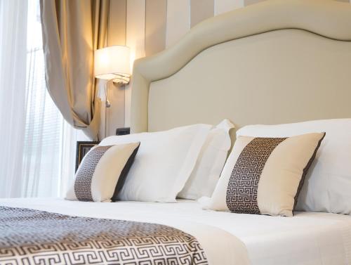 a bedroom with a white bed with white pillows at Hotel Tigullio Et De Milan in Santa Margherita Ligure