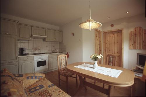 een keuken met een houten tafel en een eetkamer bij Ferienwohnung "Am Waldsaum" in Kurort Gohrisch