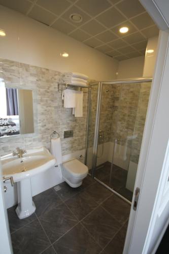 a bathroom with a toilet and a sink and a shower at Hotel Naumpasa Konagi in Istanbul