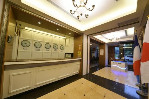 a restaurant with a counter and clocks on the wall at Sunrise Business Hotel - Tamsui in Tamsui
