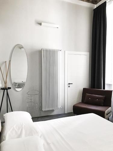 a bedroom with a bed and a mirror and a chair at Piazza Castello Suite in Turin