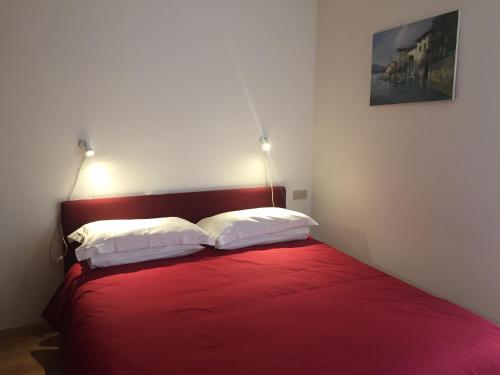 a bedroom with a red bed with two pillows at La Contessa in Lenno