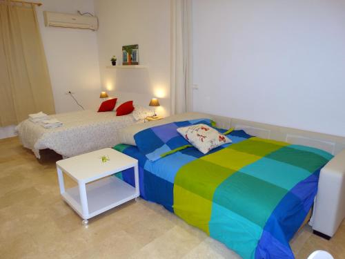 Un dormitorio con una cama colorida y una mesa pequeña. en Minimalist Loft Center by gms apartamentos, en Córdoba