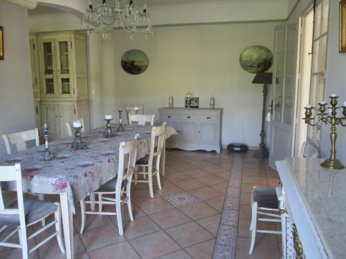 a dining room with a long table and chairs at Le Balcon De Roxane in Malaucène