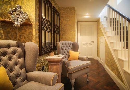 a living room with two chairs and a staircase at Padstow Townhouse in Padstow