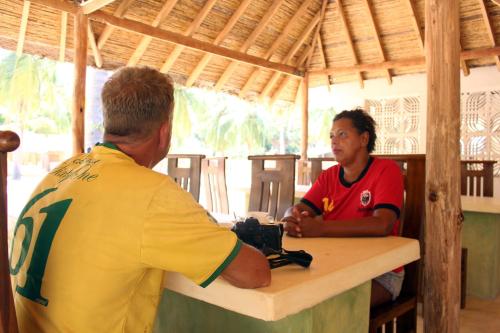 two people sitting at a table with a camera at Sandy Edge in Kalpitiya