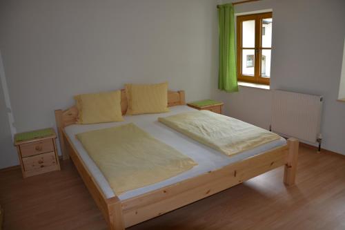a wooden bed in a room with a window at Bauernhof "Unteres Feld" in Altmünster