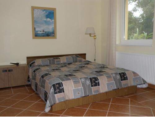 a bedroom with a bed with a quilt on it at Anker Villa in Balatonszárszó