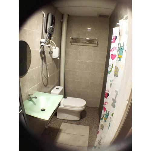 a small bathroom with a toilet and a sink at Hotel Flora Plus in Cameron Highlands