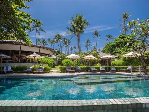 a swimming pool at a resort with chairs and umbrellas at Sea Dance Resort in Choeng Mon Beach