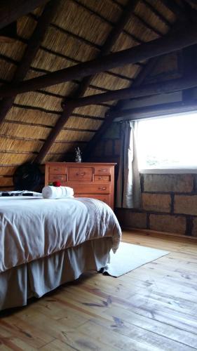 a bedroom with a bed with a dresser and a window at Blarney Stone Cottage in Killarney