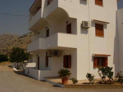 a white building with plants in front of it at Maria Apartments in Pefki Rhodes