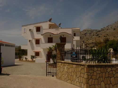 a large white house with a fence in front of it at Maria Apartments in Pefki Rhodes