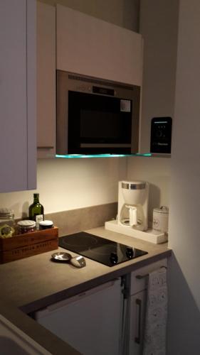 - une cuisine équipée d'un four micro-ondes et d'une cafetière sur un comptoir dans l'établissement Le 