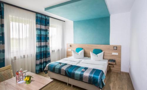 ein Schlafzimmer mit einem Bett und einem Tisch in einem Zimmer in der Unterkunft Landgasthof Büttel in Geisfeld