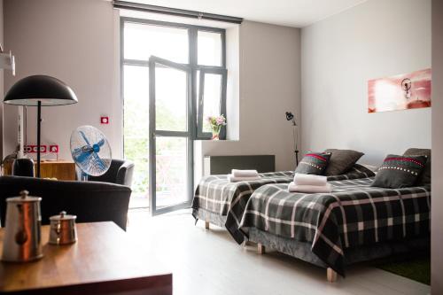 um quarto com uma cama, um sofá e uma janela em Republika Słoneczna em Poznań