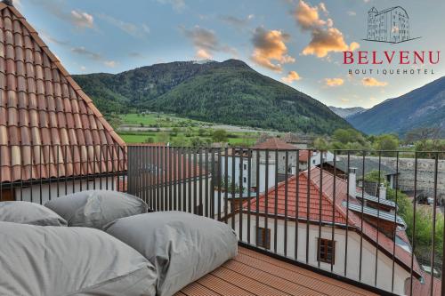 a balcony with white pillows and a view of mountains at Belvenu Boutique Hotel in Glorenza