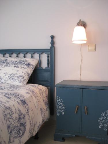 a bedroom with a blue bed with a lamp on a night stand at Apartamentos Puenteviejo in Arenas de San Pedro