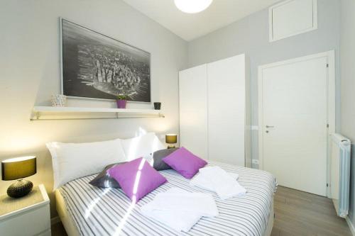 Un dormitorio con una cama con almohadas moradas. en Alloggio Casa Tua en Florencia
