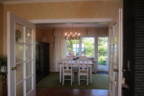 a dining room with a table and chairs and a chandelier at Exklusive Ferienwohnung Strohberg in Plön