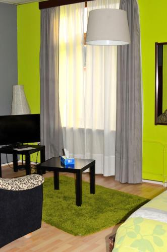 a living room with a table and a green wall at Hotel Restaurant Le Paris in Mondorf-les-Bains