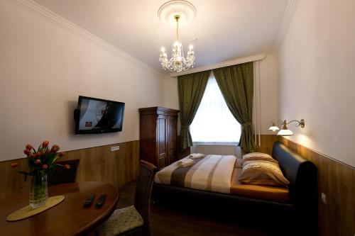 a bedroom with a bed and a table and a chandelier at Apartment Karla Capka Street in Karlovy Vary