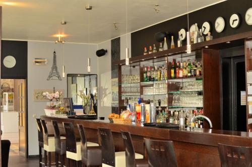 a bar in a restaurant with chairs around it at Hotel Restaurant Le Paris in Mondorf-les-Bains