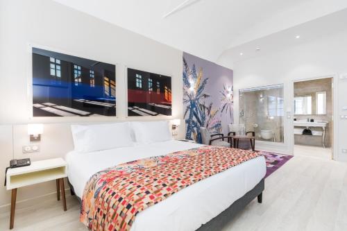 a bedroom with a large white bed and large windows at Palais Saleya Boutique Hôtel in Nice