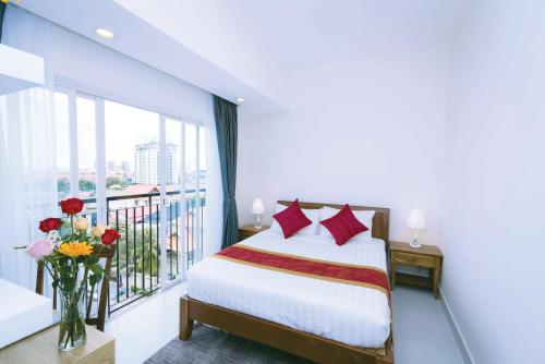Un dormitorio con una cama y un balcón. en Sun Apartment, en Phnom Penh