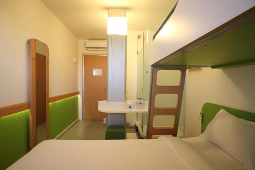 a bedroom with a bunk bed and a bathroom at Cordia Hotel Surabaya Airport - Hotel Dalam Bandara in Sidoarjo