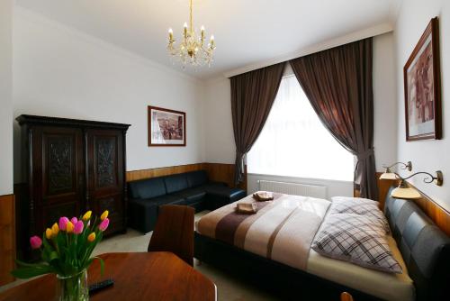 a bedroom with a bed and a couch and a table at Apartment Karla Capka Street in Karlovy Vary