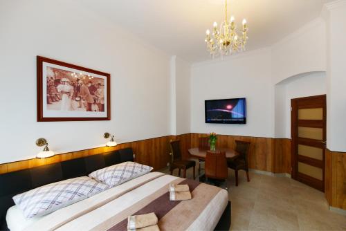 a bedroom with a bed and a table and a chandelier at Apartment Karla Capka Street in Karlovy Vary