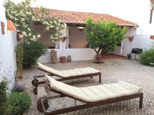 a courtyard with couches and trees and a building at Casa da Galega in Golegã