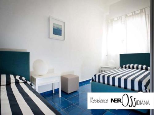 a bedroom with two beds and a table and a desk at NerOssidiana in Acquacalda
