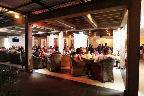 a group of people sitting at tables in a restaurant at Thilanka Hotel in Kandy