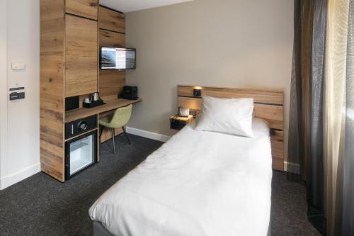 a hotel room with a bed and a desk at Theaterhotel Venlo in Venlo