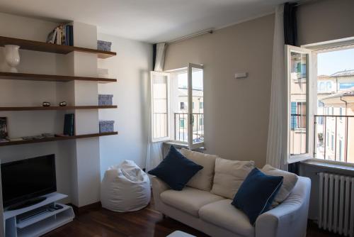 sala de estar con sofá, TV y 2 ventanas en IN PIAZZA appartamento con vista, en Lazise